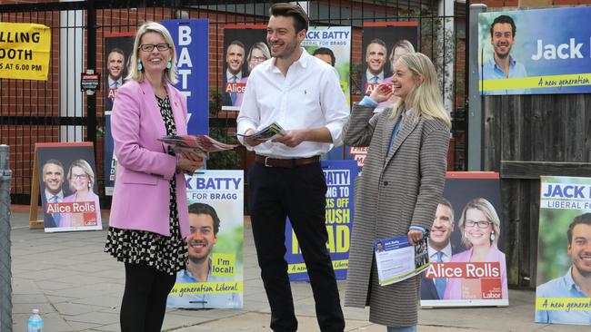 Opposing Bragg candidates Alice Rolls and Jack Batty with wife Charlotte, sharing a humorous moment, at the Glenunga High School. Picture: Dean Martin