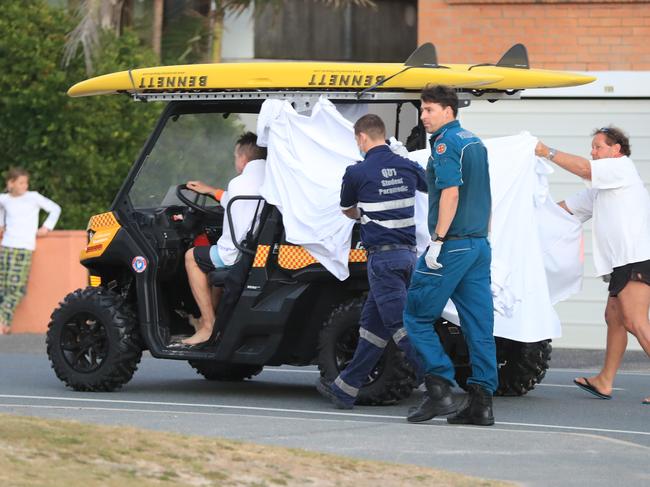 The victim is transferred to a waiting ambulance. Picture: Scott Powick