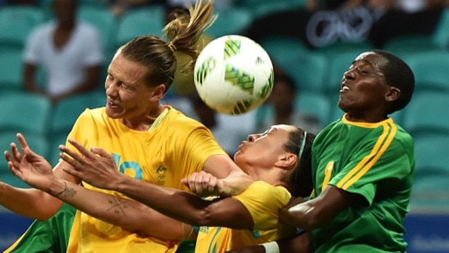 Emily Van Egmond (L) and Kyah Simon (C) of Australia vie for the ball with Lynett Mutokuto.