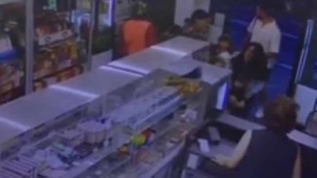 A terrified mother pushes her children into a shop as the incident unfolds.