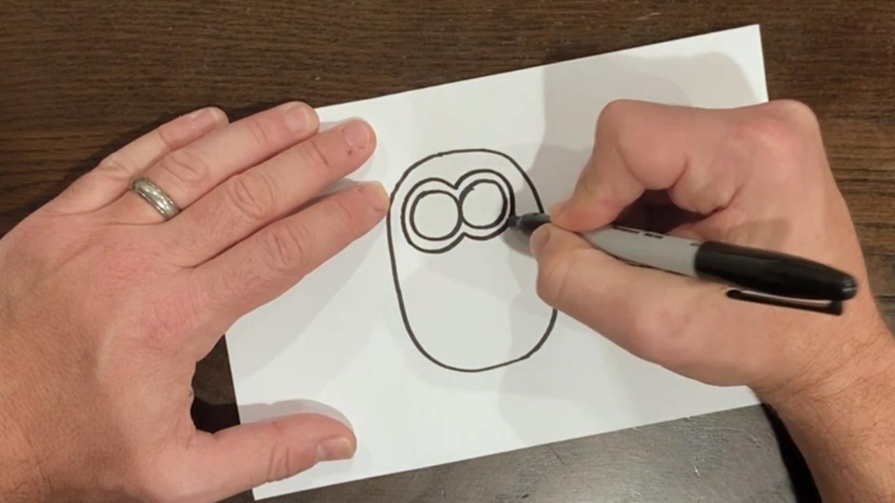 Step 4: draw the minion’s goggles around his eyeballs.