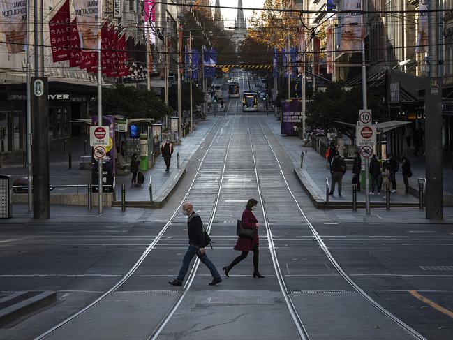 MELBOURNE, AUSTRALIA - JUNE 02: People wearing face masks cross Bourke Street on June 02, 2021 in Melbourne, Australia. Lockdown restrictions remain in place across Victoria in response to a growing COVID-19 cluster in Melbourne's northern suburbs. Residents can only leave home for five reasons: care and caregiving, exercise, work and to buy groceries, or to get vaccinated. (Photo by Daniel Pockett/Getty Images)