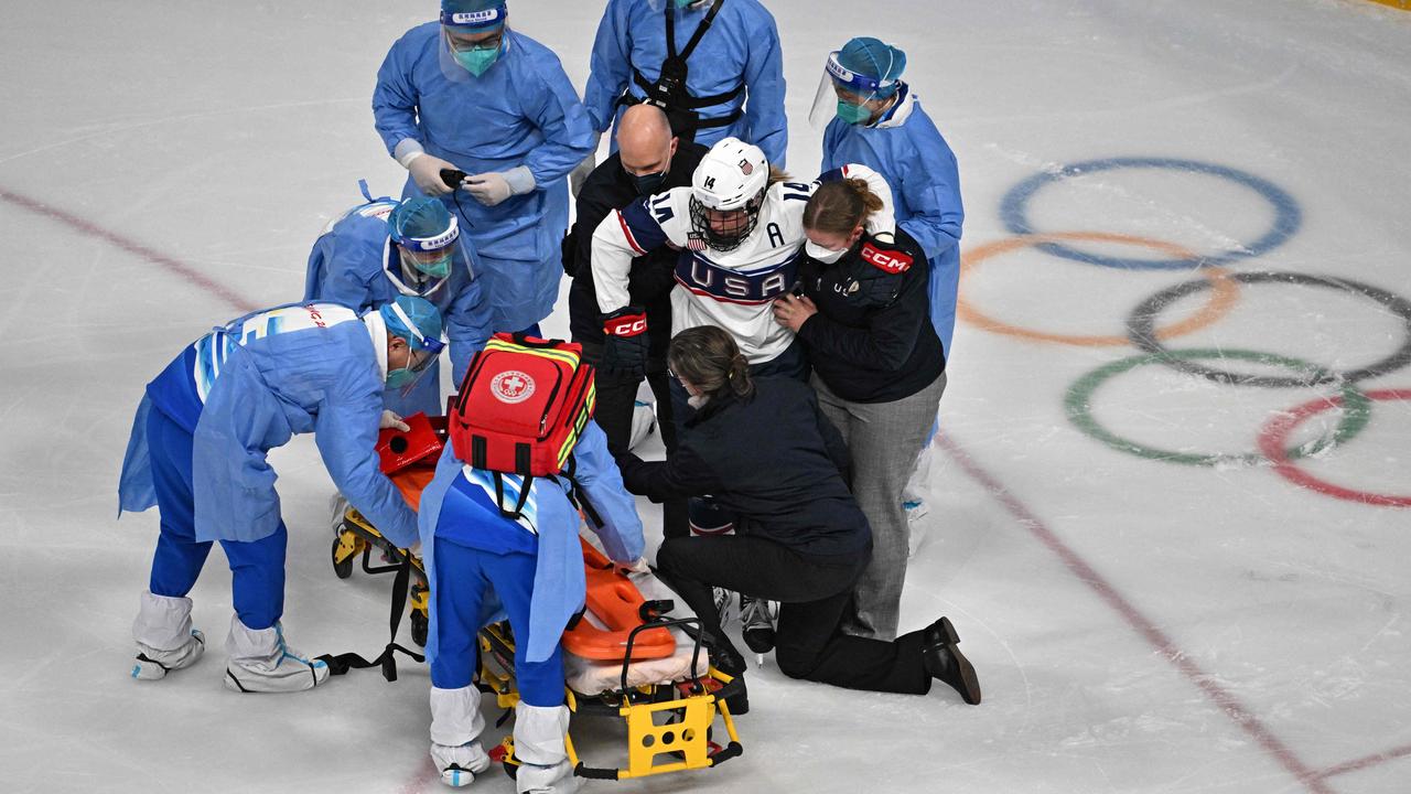 USA's Brianna Decker is taken out of the rink on a trolley after colliding with Finland's Ronja Savolainen. Photo by ANTHONY WALLACE / AFP.