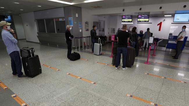 Socially-distanced passengers line up to check in their luggage. Picture: Darko Vojinovic/AP