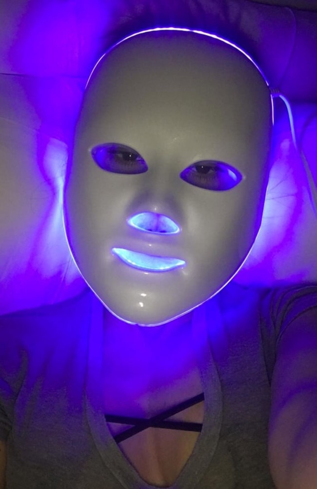 Kourtney Kardashian using an at-home blue light treatment mask.