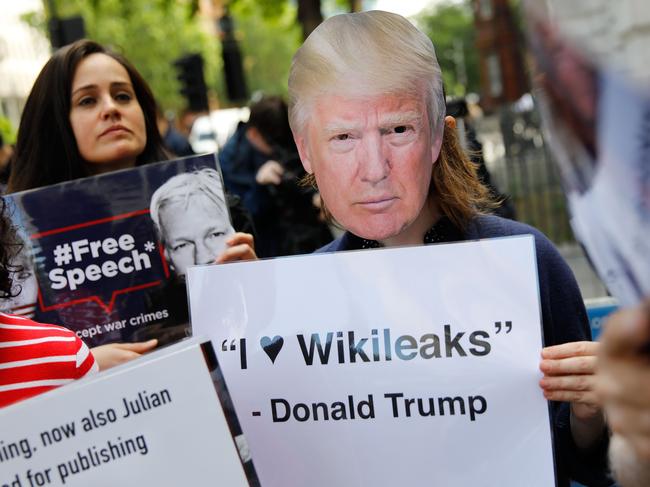 Assange supporters, including one wearing a Donald Trump mask, hold placards as they protest outside Westminster Magistrates Court. Picture: AFP