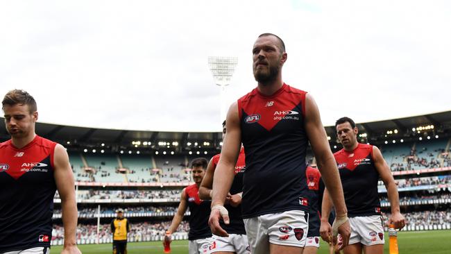 Melbourne players trudge off the MCG after losing their final-round game to Collingwood and costing themselves a finals berth. Picture: AAP Image/Tracey Nearmy