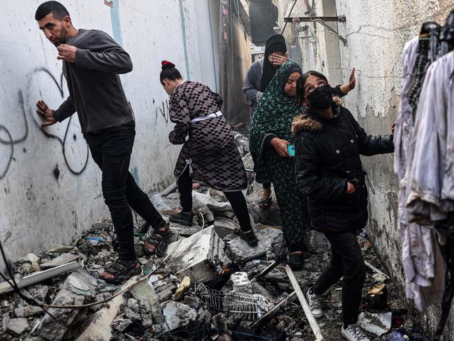 People find their way through a rubble-covered alley, following overnight Israeli bombardment in Rafah in the southern Gaza Strip on February 25. Picture: Said Khatib/AFP