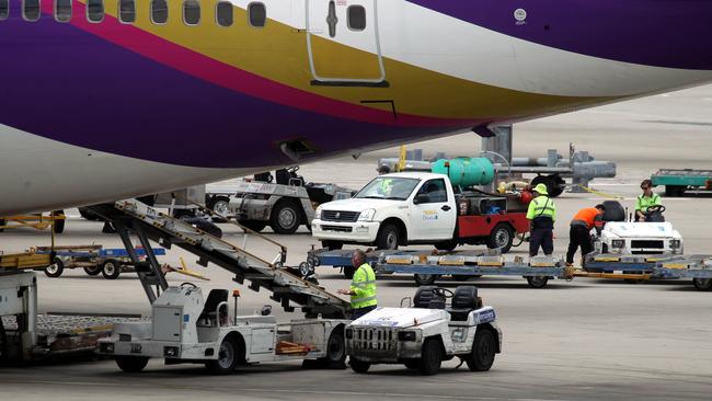 Busy job. Baggage handlers in action at Sydney Airport. Picture: News Corp Australia