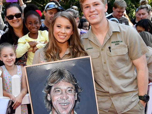 Bindi Irwin and Robert Irwin with a portrait of their late father Steve Irwin today. Picture: AAP