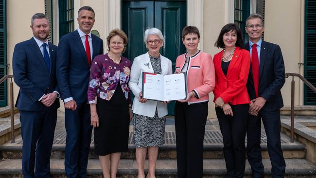 University of Adelaide Chancellor Catherine Branson and University of South Australia Chancellor Pauline Carr with a formal agreement to investigate a merger. Picture: Naomi Jellicoe