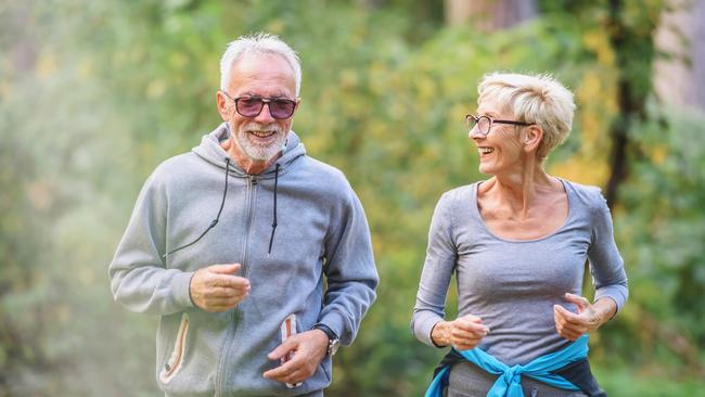 Smiling senior couple jogging in the park. Sports activities for elderly people. Active seniors generic