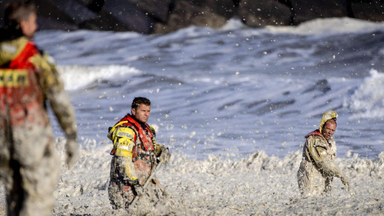 Rescue workers stand in rough waters during the resumed search for missing water sports participants at Scheveningen, The Netherlands.