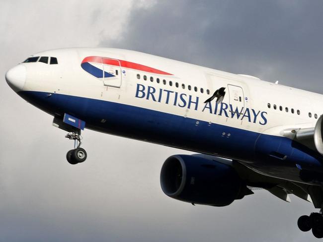 A British Airways Boeing 777-236 aircraft flies over residential houses as it prepares to land at London Heathrow Airport in west London on February 5, 2021. - Britain confirmed Thursday it will introduce its new mandatory hotel quarantine rules for travellers returning from dozens of countries deemed at "high risk" from Covid-19 variants later this month. The policy, which will begin from February 15, will require all UK citizens and permanent residents returning from countries on its so-called travel ban list to self-isolate in a government approved facility for 10 days. (Photo by Adrian DENNIS / AFP)