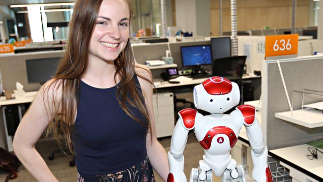 Nicole Robinson is a psychology PhD student at QUT who is working with robots. She is with "Andy". Pic Annette Dew