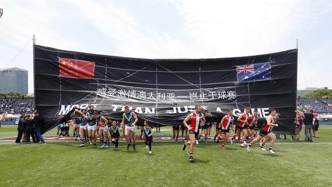 The Saints and Power run through a joint banner during last year’s game in Shanghai. Picture: Michael Willson/AFL Photos