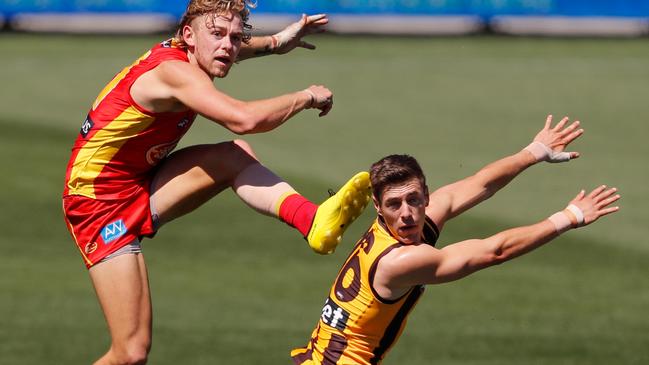 ADELAIDE, AUSTRALIA - SEPTEMBER 20: Hugh Greenwood of the Suns kicks the ball past James Cousins of the Hawks during the 2020 AFL Round 18 match between the Hawthorn Hawks and the Gold Coast Suns at Adelaide Oval on September 20, 2020 in Adelaide, Australia. (Photo by Matt Turner/AFL Photos via Getty Images)