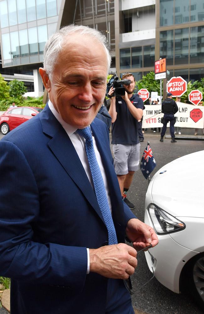 Prime Minister Malcolm Turnbull is seen near anti-Adani mine protesters as he walks to his car at the LNP campaign launch. Picture: AAP/Darren England