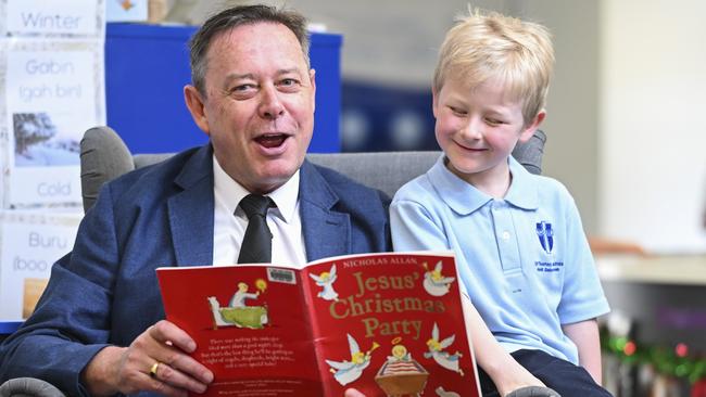 Year 3 student Harris reads with principal Tim Cleary at St Thomas Aquinas Primary School in Canberra. Picture: Martin Ollman