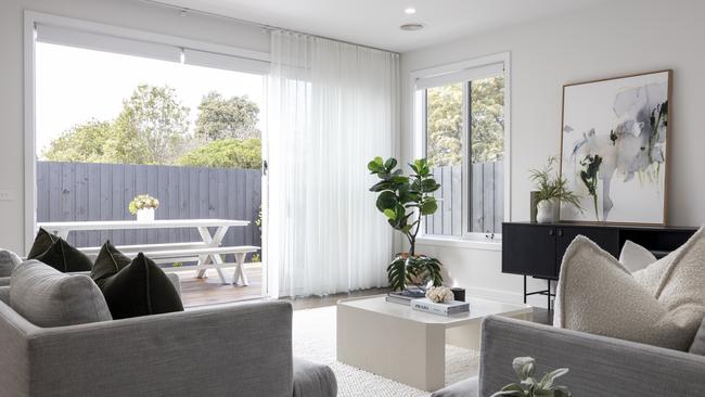 A glass sliding door connects the living zone to an outdoor deck.