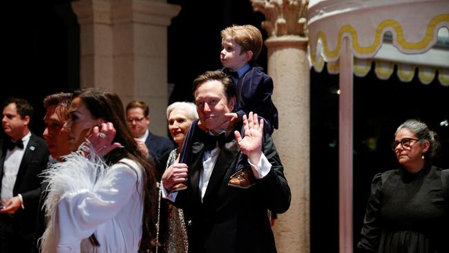 Elon Musk holds his son on his shoulders as he attends a New Year's Eve event held by US President-elect Donald Trump at Mar-a-Lago in Palm Beach, Florida. Picture: Reuters