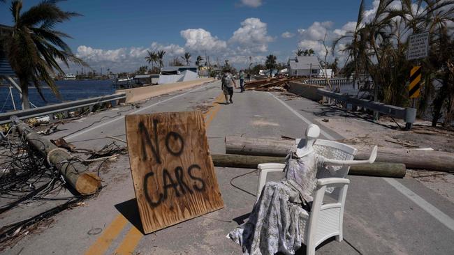 TOPSHOT - A man walks on a street in the aftermath of Hurricane Ian in Matlacha, Florida on October 1, 2022. - Shocked Florida communities counted their dead October 1, 2022, as the full scale of the devastation came into focus, two days after Hurricane Ian tore into the coastline as one of the most powerful storms ever to hit the United States. (Photo by Ricardo ARDUENGO / AFP)