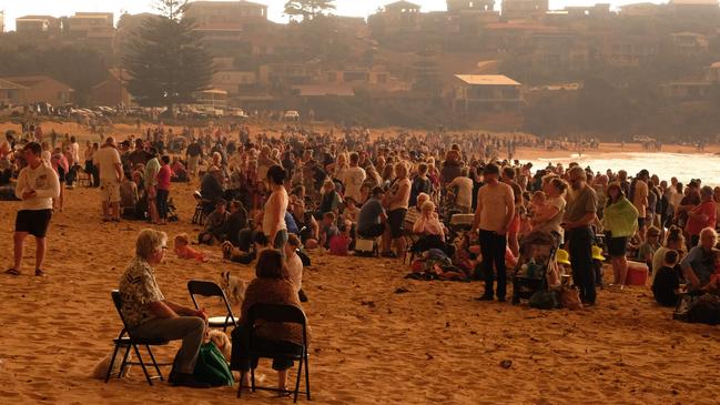 Malua Bay residents seek refuge on the beach as the fire approaches. Picture: Alex Coppel