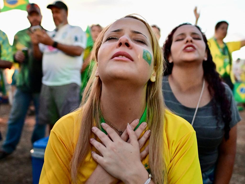 Supporters of candidate Jair Bolsonaro pray as they watch the vote count. Picture: AFP