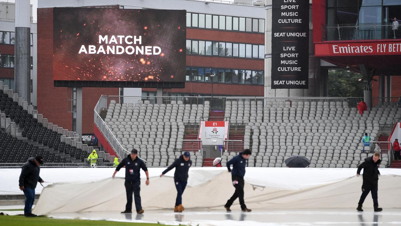 The ground staff move the covers. Photo by Gareth Copley/Getty Images