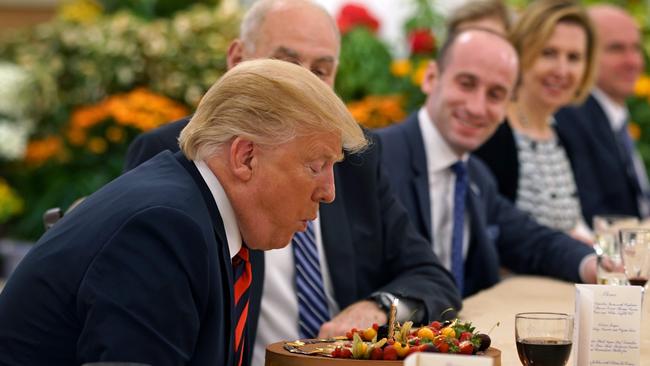 Donald Trump blows out a candle after being presented a cake during a working lunch with Singapore's Prime Minister Lee Hsien Loong (not pictured). Picture: AFP.