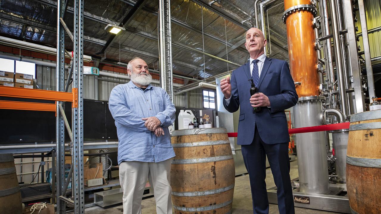 Premier Peter Gutwein and Lark Distilling Co.founder and brand ambassador Bill Lark with the new column still used for making hand sanitiser at Cambridge. Picture Chris Kidd