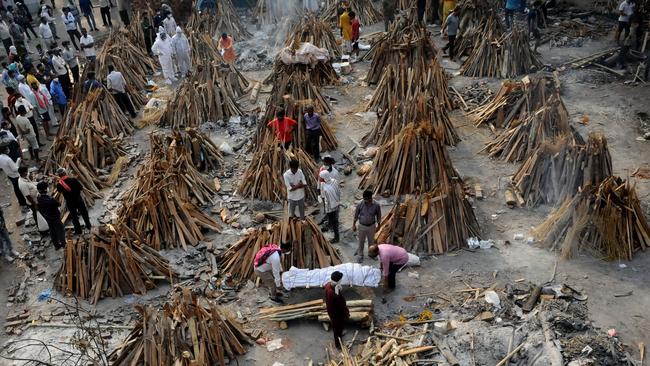 People prepare funeral pyres of those who died from coronavirus, during a mass cremation in New Delhi, India. Picture: Getty