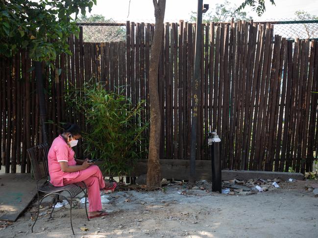 A nurse rests at a NGO-run station providing supplemental oxygen on a pedestrian pavement on May 8, in Bengaluru, India. Hospitals have begun turning away people suffering from COVID-19, having run out of space for people seeking help. Picture: Abhishek Chinnappa/Getty Images