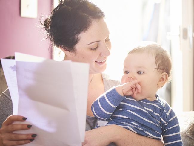 A young mother reads through a legal pack from her insurance company or solicitor. She is making provisions for the future of her child. life insurance generic, family protection