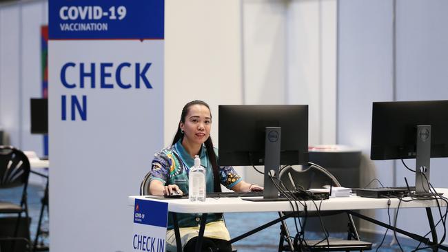 Administration staff member Jacky Ramsay at the check in counter of a mass vaccination hub set up in the Cairns Convention Centre. Picture: Brendan Radke