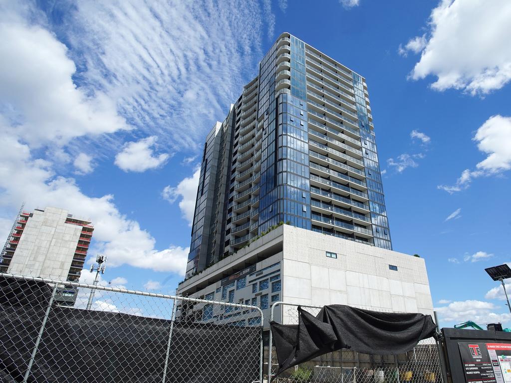 Liberty 1 building in Footscray with diggers in the front where Liberty 2 was to be built. Homes under construction hang in balance as Bensons Property Group enters administration, Picture: NewsWire / Luis Enrique Ascui