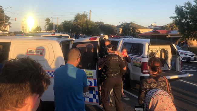 A woman is put into the back of a police van outside Labrador State School.