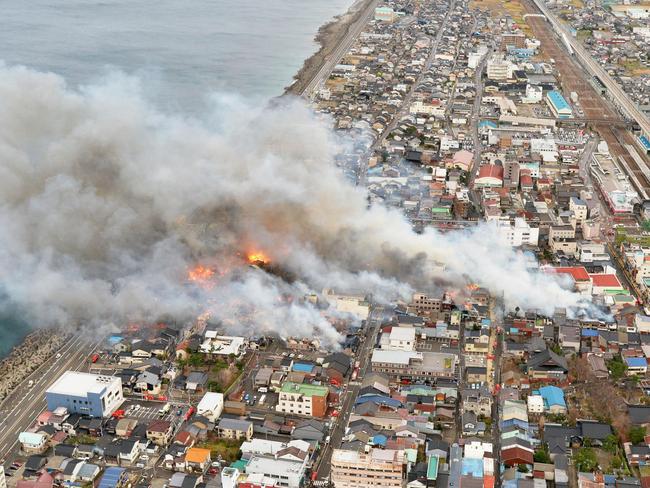 Smoke billow during a fire in Itoigawa, northern Japan, Thursday, Dec. 22, 2016. A fire whipped by high winds has spread to at least 140 buildings in a small Japanese city on the Japan Sea coast. The fire department says the blaze started at a restaurant in Itoigawa city Thursday morning. By mid-afternoon, 140 houses and other buildings had caught fire, and the fire is still spreading. (Kyodo News via AP)