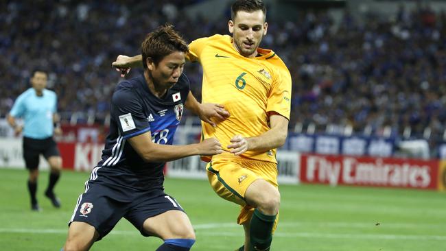 Japan's Takuma Asano, left, and Australia's Matthew Spiranovic compete for the ball