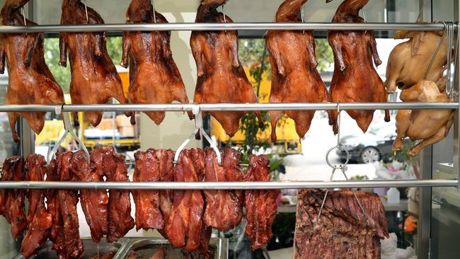 Duck and roast pork hang in the window of a Chinese restaurant.