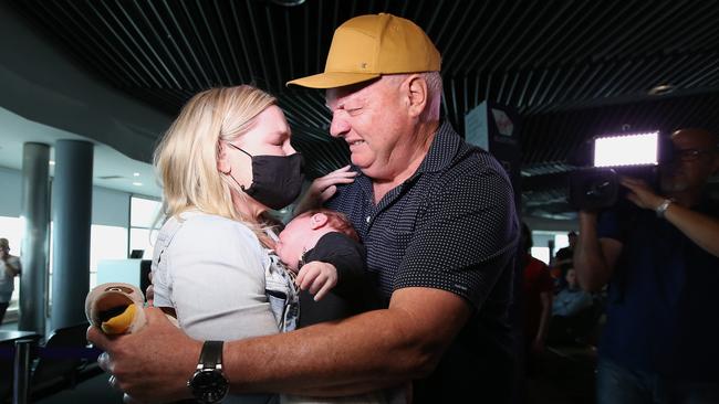 Grandfather Cole meets his grandson Ted for the first time, with daughter Lauren, after both Ted and Lauren arrived on the first flight from Melbourne since the Queensland border reopened in Brisbane. Picture: Jono Searle/Getty Images