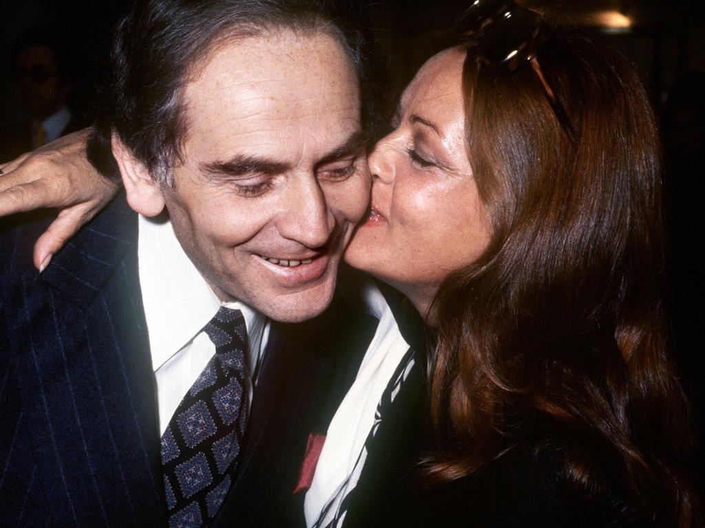 (FILES) This file photo taken on October 13, 1972 shows French actress Jeanne Moreau (R) kissing her friend fashion designer Pierre Cardin. - French fashion designer Pierre Cardin, hailed for his visionary creations but also for bringing stylish clothes to the masses, died on December 29, 2020 aged 98, his family told AFP. Cardin who was born in Italy in 1922 but emigrated to France as a small child, died in a hospital in Neuilly in the west of Paris, his family said. (Photo by - / AFP)