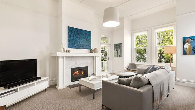 A formal lounge room at the front of the home is full of natural light.