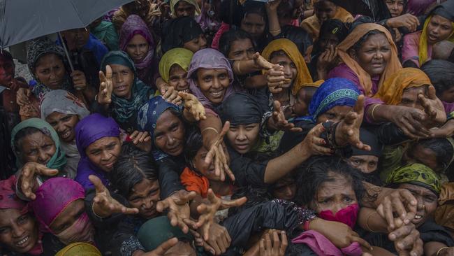 Rohingya Muslim women, who crossed over from Myanmar into Bangladesh after fleeing violence in Myanmar, stretch their arms out to collect sanitary products distributed by aid agencies near Balukhali refugee camp, Bangladesh. No one has been prosecuted for the rape of thousands of Rohingya women by Burmese soldiers Picture: AP