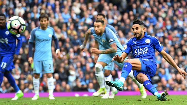 Leicester City's Algerian midfielder Riyad Mahrez (R) slips after taking his penalty.