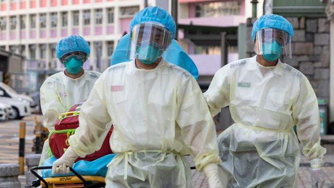 (FILES) This file photo taken on August 23, 2020 shows medical staff wearing personal protective equipment (PPE) as a precautionary measure against the COVID-19 coronavirus approaching a care home in Hong Kong. - The majority of deaths in the city's latest Covid-19 wave are the elderly, Hong Kong's most vaccine-hesitant population, and more than half are tenants in overcrowded care homes across the city. (Photo by May JAMES / AFP) / TO GO WITH Health-virus-HongKong-China-elderly,FOCUS by Su Xinqi