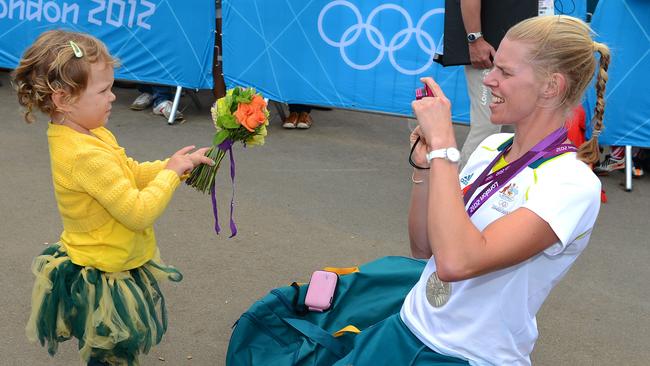 Sarah Tait greeted by her daughter Leila, 3, after the Women’s Pair final in 2012. Leila is holding the ceremonial flowers.