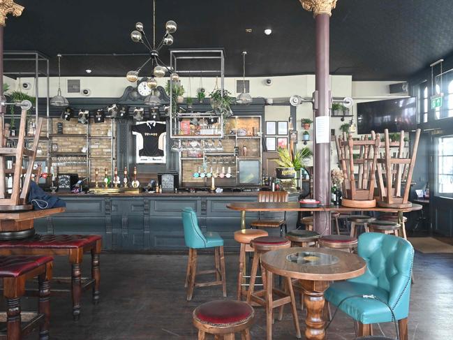 Tables and chairs are seen stacked through the window of a closed pub in London. Picture: AFP