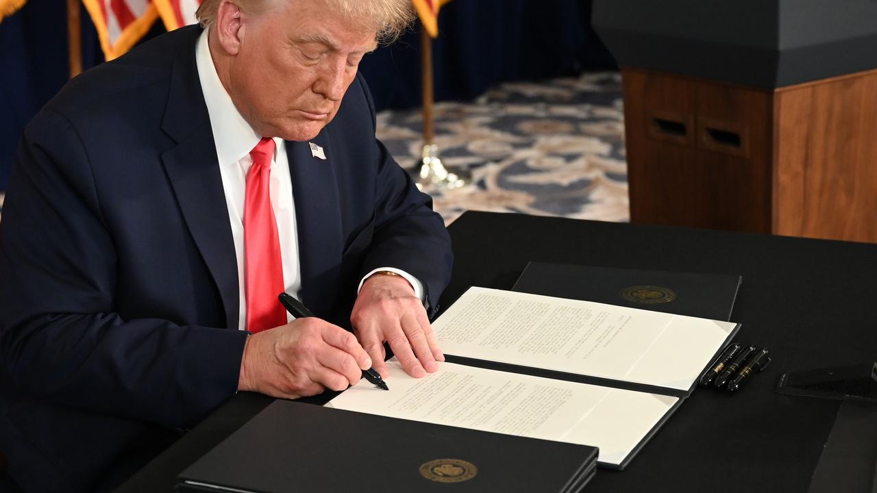 Mr Trump signing the orders. Picture: Jim Watson/AFP