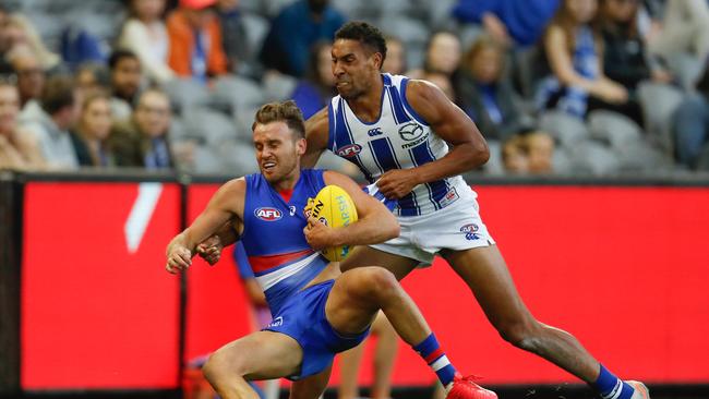 Aiden Bonar of North Melbourne wraps up Hayden Crozier of the Bulldogs